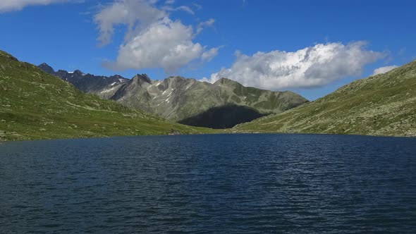 Time-lapse view on peak of mountains and lake in Swiss Alps