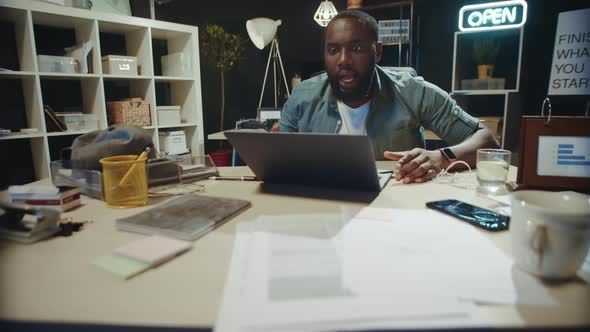 Frustrated African American Guy Checking Project Result Online in Dark Office. alt