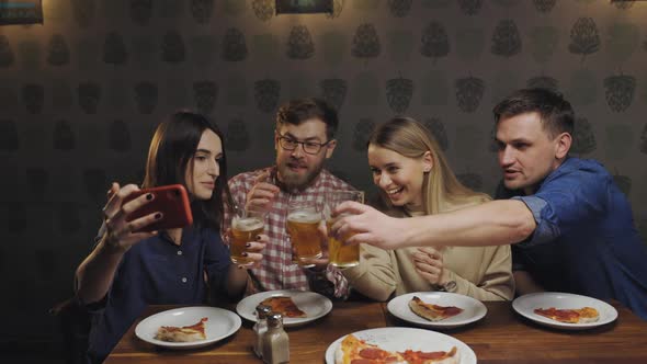 Happy People in Pub Eat Pizza and Talk By Videocall with Friends