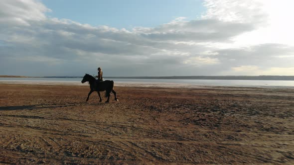 Woman Rides Horse on Beautiful Autumn Nature Landscape By River or Lake. alt