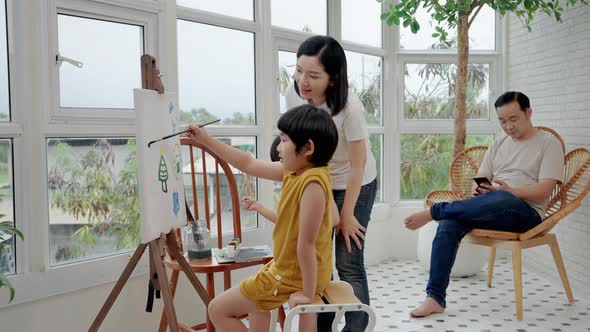 Asian family with father Mother and son are working together to paint and paint in the living room.