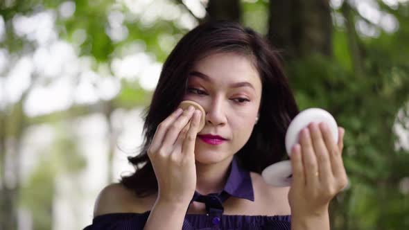 woman applying make up with powder puff