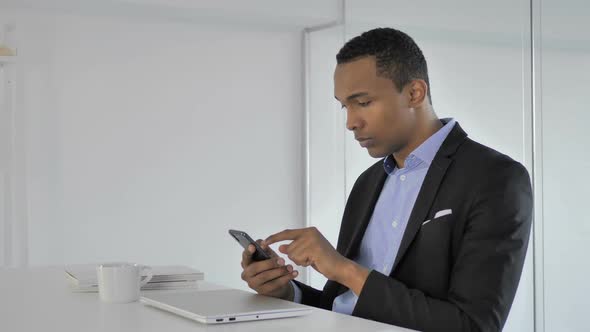 Casual AfroAmerican Businessman Using Smartphone Typing Message alt