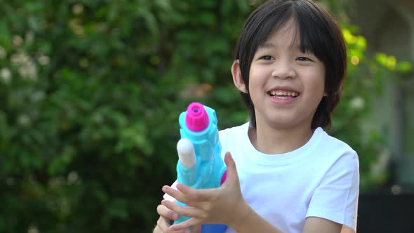 Cute Asian Child Playing With Water Gun In The Summer alt