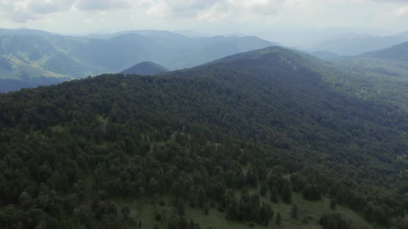 Valley and green deep forest on mountains of Manzherok under blue sky