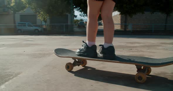 Toddler Girl Learning Ride on Skateboard on Sport Field alt