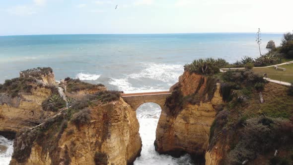 Stone Bridge connecting eroded cliffs in Student Beach In Lagos, Algarve, Portugal  alt