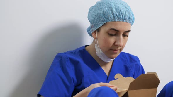 Sad Doctor or Nurse Eating Takeaway Food From Box alt