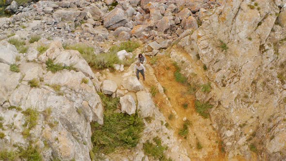 Couple are climbing on a rock Summer Baikal lake Olkhon island alt