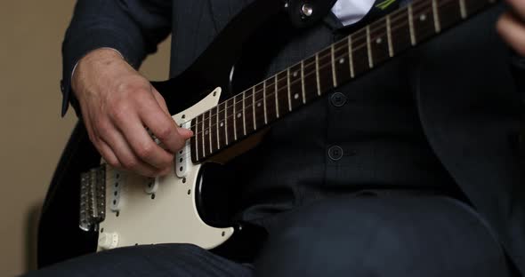 Man in Dark Outfit Sitting and Playing on Beautiful Guitar Jazz Music