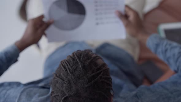 Young Overburdened Man Falling Asleep Examining Business Graph in Home Office alt