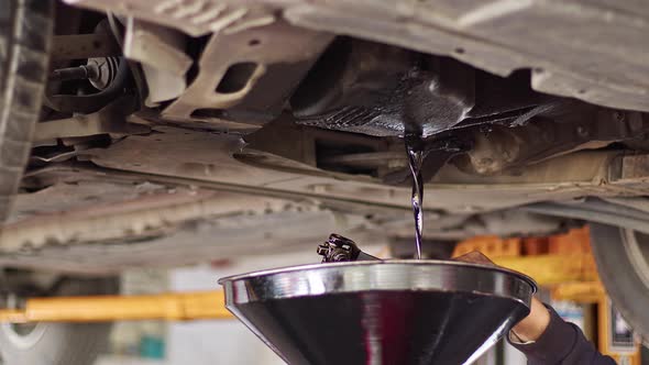 Old Oil Is Drained From Car Engine alt