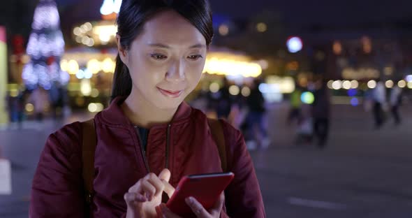 Woman use of mobile phone in city at night alt