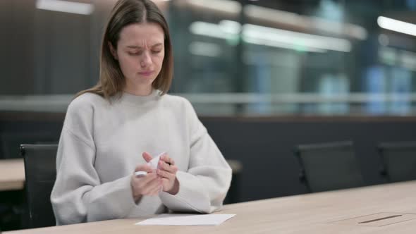 Frustrated Woman Writing on Paper in Office alt