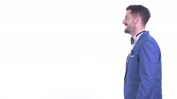 Profile View of Happy Young Handsome Bearded Businessman Pointing Finger alt