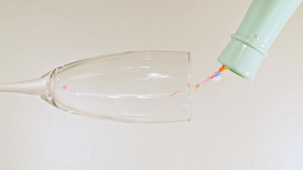 Colorful Candy Confectionery Run Poured Into a Wineglass Glass on Green Background alt