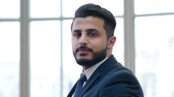 Arabian businessman looks at his watch, then looking at the camera