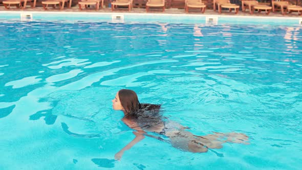 Girl in Leopard Swimsuit Playing in the Pool Under the Summer Sun alt