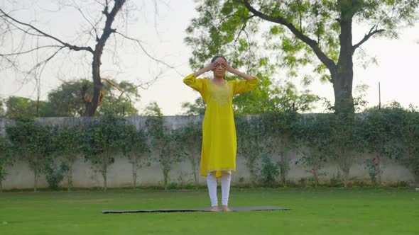 Indian man doing Bhramari Pranayama or the bee breath yoga pose in an Indian outfit alt