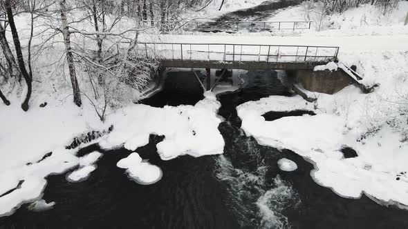 Winter Landscape with a Stormy River and a Bridge Aerial View alt