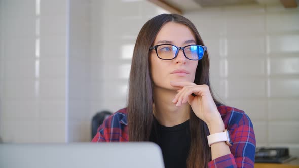 Freelancer woman in nerdy glasses working on laptop computer at home on lockdown un 4k footage alt