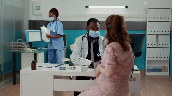 Pregnant Patient Meeting with Doctor in Cabinet During Covid 19 Pandemic alt