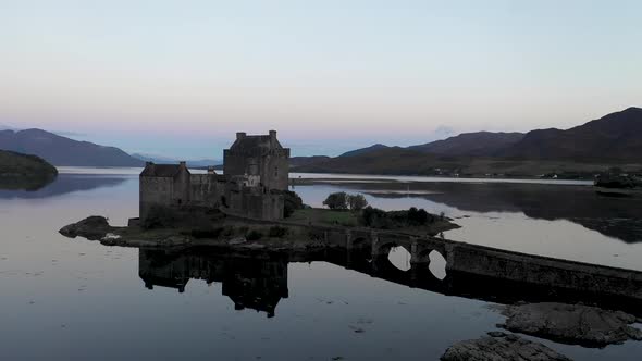 Aerial view of Eilean Donan Castle and lake Loch Duich in Scotland at sunrise