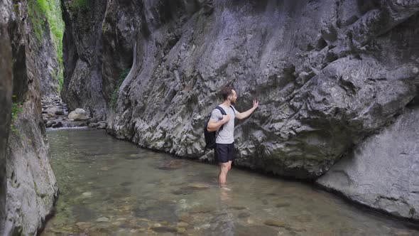 Man walking on creek in canyon. alt