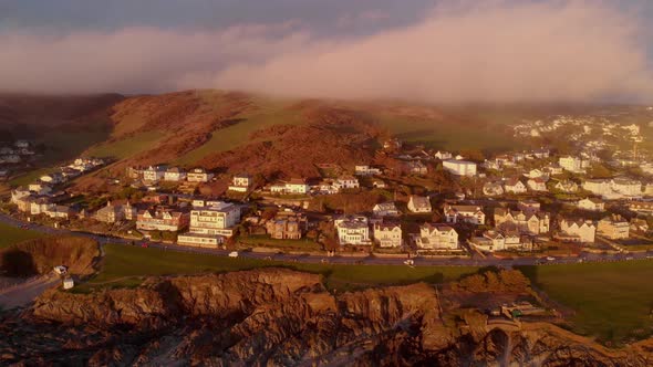 Aerial View Woolacombe Village, Rocky Coast With Clouds Sitting Over Hills In Winter At Sunset