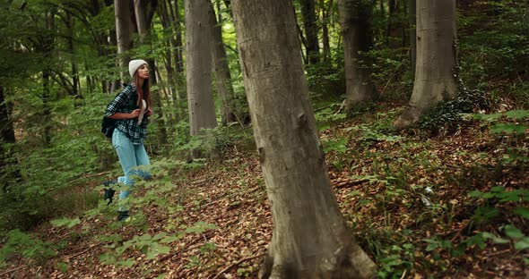 Woman with Backpack Hiking in Forest