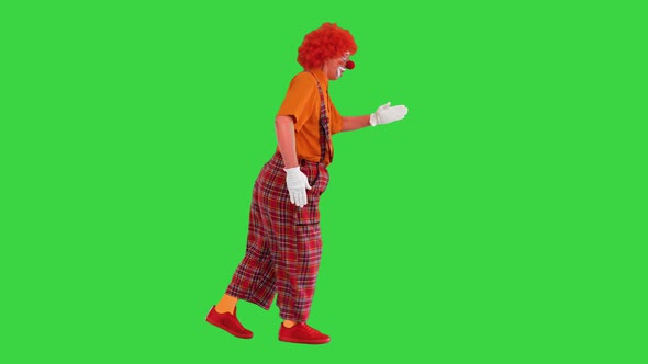 Clown in a Red Outfit Walking Like a Robot on a Green Screen Chroma Key alt