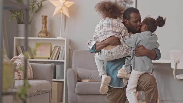 Father Hugging Two Little Daughters alt