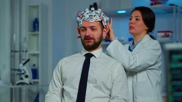 Neurologist Doctor Analysing Brain of Man Using Brainwave Scanning Headset alt