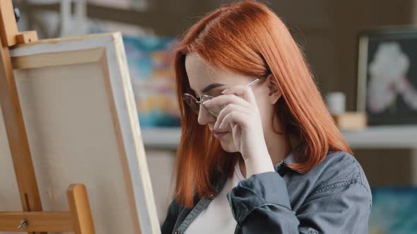 Caucasian Woman Artist Girl Painter with Red Hair Put on Eyeglasses Wearing Glasses Start Art Work alt