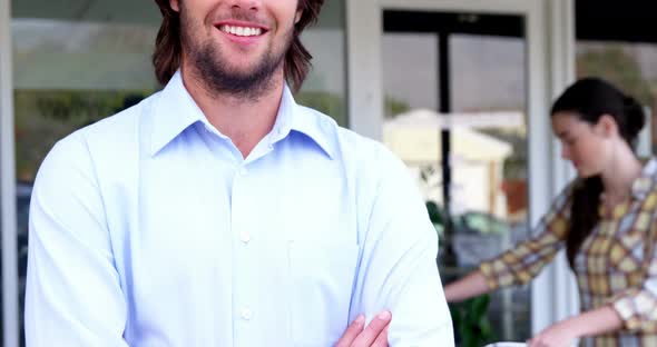 Portrait of man standing with arms crossed alt