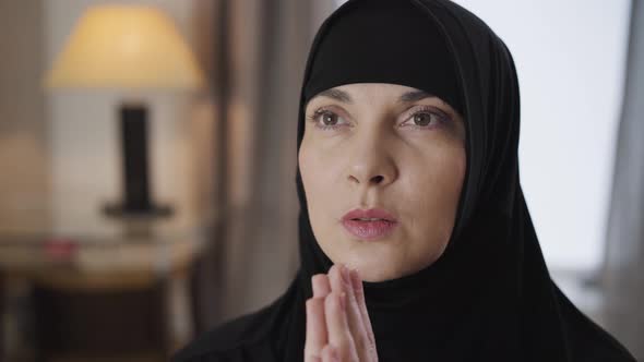 Close-up Face of Young Beautiful Muslim Woman Holding Hands Together and Praying. Lady in Black alt