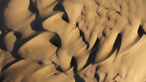  Aerial Drone View Zooming Out Massive Wavy Sand Dunes in Golden Sunset Light alt