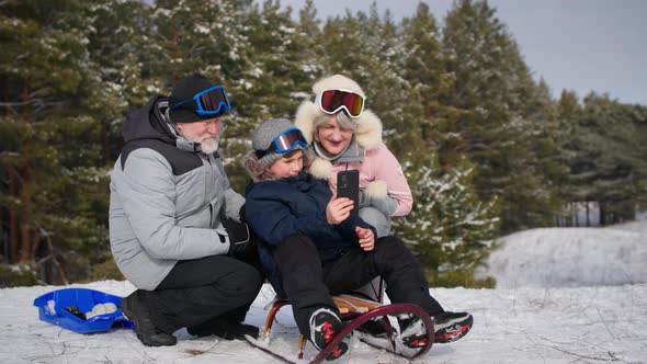 Outdoor Recreation Happy Boy Together with Grandparents Have Fun Filming Video on Mobile Phone