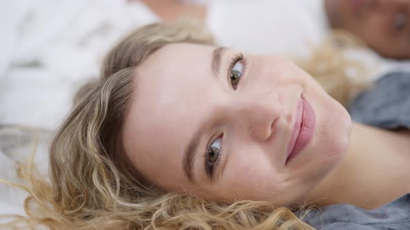 Headshot Portrait of Cheerful Slim Gorgeous Caucasian Blond Woman Looking at Camera Lying in Cozy alt