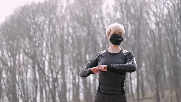 A Middle-aged Woman in a Mask Is Doing Morning Exercise Outside alt