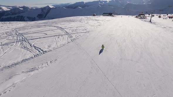 Back View From Drone of Male Riding Ski From Slope in Slowmotion alt