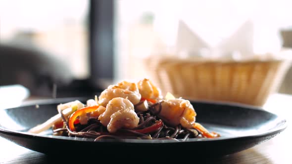 Sesame Seeds is Falling on Traditional Asian Soba Stirfry Noodles with Shrimp