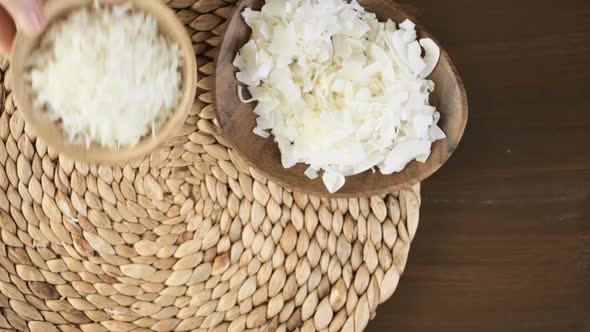 Dehydrated coconut flakes on a wood background. alt