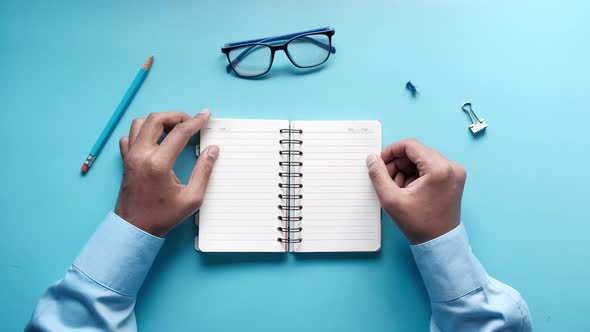 Top View of Man's Hand Turning a Pager of a Diary alt