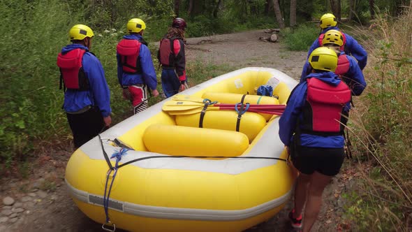 Group of people white water rafting carry raft together