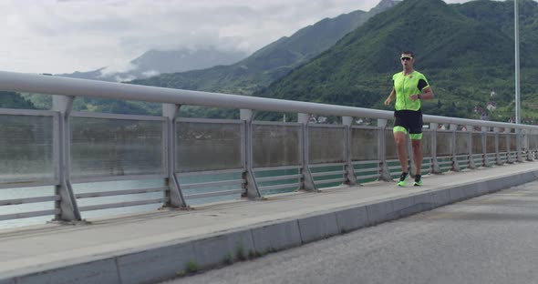 Triathlon  Male Triathlete Running in Triathlon Suit Training for Ironman Race alt