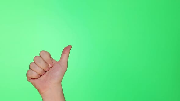 Thumb, well, good sign. Closeup of male hand isolated on green screen background alt