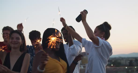 Young students dancing during a party with sparklers