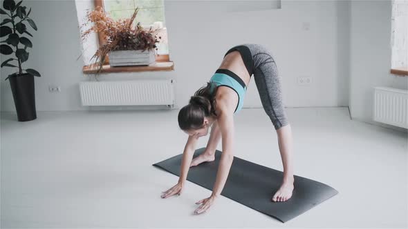 Young Sporty Brunette Girl in Sportswear Does Exercises in Bright Room at Home alt