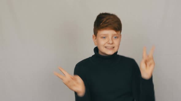 Portrait of a Funny Redhead and Blueeyed Teenager Boy Funny and Fun Dancing in Front of the Camera